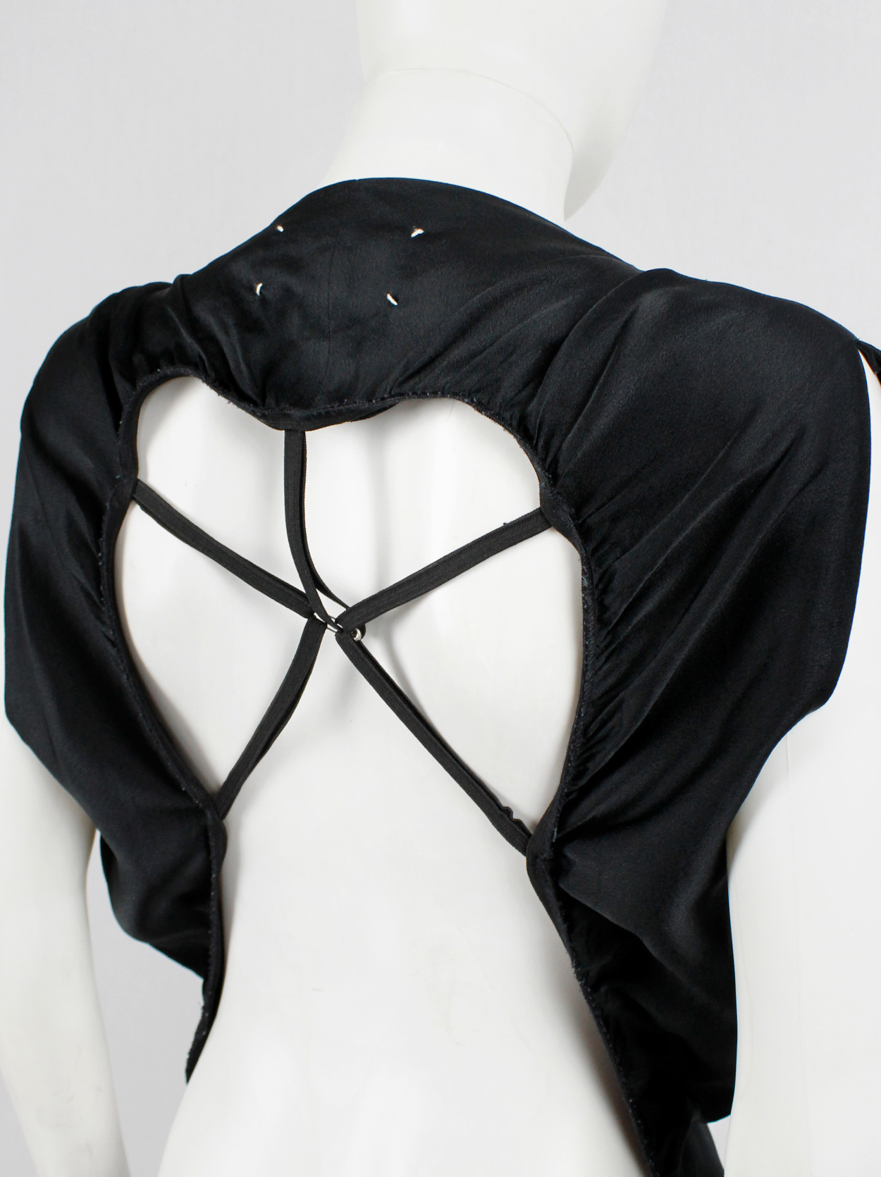 Maison Martin Margiela black backless dress with straps modeled after a ...